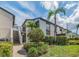 Condo exterior with stairs leading to units and vibrant landscaping with palm trees at 2597 Countryside Blvd # 210, Clearwater, FL 33761