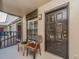 View of unit 210's front door from the balcony with a small table and chair at 2597 Countryside Blvd # 210, Clearwater, FL 33761