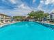 Community swimming pool with lounge chairs and shade for relaxing by the water at 2597 Countryside Blvd # 210, Clearwater, FL 33761