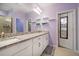Elegant bathroom with dual sinks, granite countertop, and modern fixtures, illuminated by vanity lights at 2816 Grand Kemerton Pl, Tampa, FL 33618