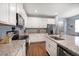 Modern kitchen boasts white cabinets, stainless steel appliances, granite countertops, and bar seating at 2816 Grand Kemerton Pl, Tampa, FL 33618