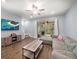 Comfortable living room with tile floors, fan, television, and view of the screened in lanai at 2816 Grand Kemerton Pl, Tampa, FL 33618