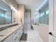 Bright bathroom featuring dual sinks, marble counters, a free-standing tub, and a glass shower at 2890 Alexandria Marie Ln, Lutz, FL 33559