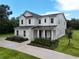 Stunning two-story home featuring black metal roof accents, a covered entry, and landscaped frontage at 2890 Alexandria Marie Ln, Lutz, FL 33559