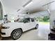 Spacious garage showcasing a luxury SUV, ample storage space, and a bright, clean environment at 2890 Alexandria Marie Ln, Lutz, FL 33559