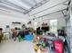 View of a cluttered garage, offering ample storage space and natural light from windows at 2890 Alexandria Marie Ln, Lutz, FL 33559