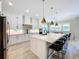 Modern kitchen featuring a spacious island with seating, stainless steel appliances, and white cabinetry at 2890 Alexandria Marie Ln, Lutz, FL 33559