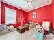 Vibrant playroom with red walls, ample natural light, and an array of toys for creative play at 2890 Alexandria Marie Ln, Lutz, FL 33559