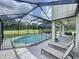 A backyard paradise featuring a screened pool, lounging area, and covered patio for outdoor living at 2890 Alexandria Marie Ln, Lutz, FL 33559