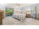 This main bedroom features a large bed, sliding glass doors to a patio, and neutral colors at 2919 Fig Ct, Palm Harbor, FL 34684