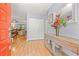 Inviting entryway with wood floors, console table, and orange front door offering a warm welcome to the home's interior at 2919 Fig Ct, Palm Harbor, FL 34684