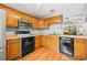 Well-lit kitchen with wood cabinets, modern appliances, and a view to the dining room at 2919 Fig Ct, Palm Harbor, FL 34684