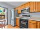 Cozy kitchen featuring wood cabinets, modern appliances, and a view to the outdoor patio at 2919 Fig Ct, Palm Harbor, FL 34684
