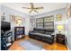 Cozy living room features a ceiling fan, plush black sofa, and shelving with books and decor at 2919 Fig Ct, Palm Harbor, FL 34684