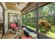 Inviting sunroom with comfortable wicker chairs, lots of windows, and views of the backyard landscaping at 2919 Fig Ct, Palm Harbor, FL 34684