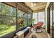 Bright sunroom with large windows offering views of lush greenery, plus a ceiling fan and rocking chair at 2919 Fig Ct, Palm Harbor, FL 34684