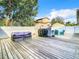 Outdoor wooden deck features a grill, seating, and view of the fenced backyard for entertaining at 2928 W Arch St, Tampa, FL 33607