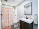 This bathroom features a framed mirror, vanity and shower with a modern curtain at 2928 W Arch St, Tampa, FL 33607