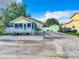 Charming yellow home with a picket fence, covered porch, and a matching storage shed, set against a bright blue sky at 2928 W Arch St, Tampa, FL 33607