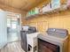 Laundry room with washer, dryer, storage shelves, utility sink, and vinyl floors at 2928 W Arch St, Tampa, FL 33607