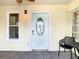 Inviting front porch with neutral paint, tiled floor, ceiling fan, front door with decorative glass, and outdoor furniture at 2928 W Arch St, Tampa, FL 33607
