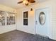 Inviting front porch with neutral paint, tiled floor, ceiling fan, front door with decorative glass, and outdoor furniture at 2928 W Arch St, Tampa, FL 33607