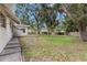 Large backyard featuring mature shade trees, green grass, and a privacy fence at the perimeter of the yard at 2956 Sutherland Ct, Palm Harbor, FL 34684