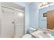 Bright bathroom featuring a glass-enclosed shower, toilet, and a vanity with sink and storage at 2956 Sutherland Ct, Palm Harbor, FL 34684