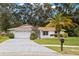 Charming single-story home with a well-maintained lawn and a driveway leading to a two-car garage at 2956 Sutherland Ct, Palm Harbor, FL 34684