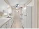 Bright kitchen featuring white appliances, cabinetry, and a double basin stainless steel sink with view to dining room at 2956 Sutherland Ct, Palm Harbor, FL 34684