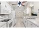 Bright kitchen featuring white appliances, cabinetry, and a double basin stainless steel sink with view to dining room at 2956 Sutherland Ct, Palm Harbor, FL 34684