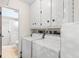 Convenient laundry area equipped with a washer, dryer, and storage cabinets next to a bathroom at 2956 Sutherland Ct, Palm Harbor, FL 34684