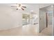 Living room with ceramic tile floors and neutral walls that looks into kitchen and has sliding glass doors at 2956 Sutherland Ct, Palm Harbor, FL 34684