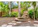 Beautiful backyard featuring a stone pond and stepping stones, surrounded by lush greenery and mature trees at 2986 Cypress Green Dr, Palm Harbor, FL 34684
