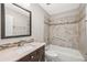 Well lit bathroom with a dark wood vanity, large mirror, bathtub and shower combo at 2986 Cypress Green Dr, Palm Harbor, FL 34684