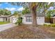 Charming front exterior with well-manicured lawn and mature trees create a welcoming curb appeal at 2986 Cypress Green Dr, Palm Harbor, FL 34684