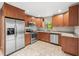 Well-lit kitchen featuring stainless steel appliances, tile flooring, and wooden cabinets at 2986 Cypress Green Dr, Palm Harbor, FL 34684