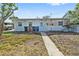 Modest backyard with a concrete path leading up to the back door of the home at 301 14Th Ave, Indian Rocks Beach, FL 33785