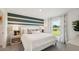 Bedroom with a decorative striped wall, bedside tables and a view of the pond at 3050 Pink Gerbera Sq, Plant City, FL 33566