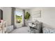 Bright home office featuring a modern desk, chair, and serene view from the large window at 3050 Pink Gerbera Sq, Plant City, FL 33566