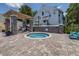 Relaxing hot tub area featuring brick pavers, stone columns, and a pergola for shade, offering a peaceful retreat at 3301 Haviland Ct # 203, Palm Harbor, FL 34684