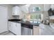 Updated kitchen with white cabinets, granite countertops, and stainless steel dishwasher, offering a bright and modern space at 3301 Haviland Ct # 203, Palm Harbor, FL 34684