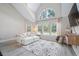 Bright living room with vaulted ceiling, large windows, modern rug and gray wood-look floors at 3301 Haviland Ct # 203, Palm Harbor, FL 34684