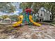 Community playground with colorful equipment and mature trees, providing a fun and safe play area for children at 3301 Haviland Ct # 203, Palm Harbor, FL 34684