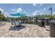Inviting outdoor patio space by the lake, featuring a barbecue grill, seating, and blue umbrella for relaxing afternoons at 3301 Haviland Ct # 203, Palm Harbor, FL 34684