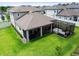 Aerial view of the backyard featuring a covered patio, screened lanai, and lush lawn at 33287 Sycamore Leaf Dr, Wesley Chapel, FL 33545
