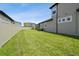 Spacious fenced backyard with lush green grass and a view of the home's exterior at 33287 Sycamore Leaf Dr, Wesley Chapel, FL 33545