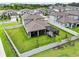 Aerial view of a backyard with a large, green lawn, white fence, and screened-in patio at 33287 Sycamore Leaf Dr, Wesley Chapel, FL 33545