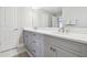 Bright bathroom featuring a double vanity, granite countertops, and contemporary gray cabinetry at 33287 Sycamore Leaf Dr, Wesley Chapel, FL 33545
