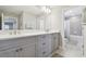 Bright bathroom with a double vanity, granite countertops, and contemporary gray cabinetry at 33287 Sycamore Leaf Dr, Wesley Chapel, FL 33545